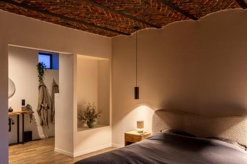 a bedroom with a bed and a wooden ceiling at Wellnesshoeve in Boutersem