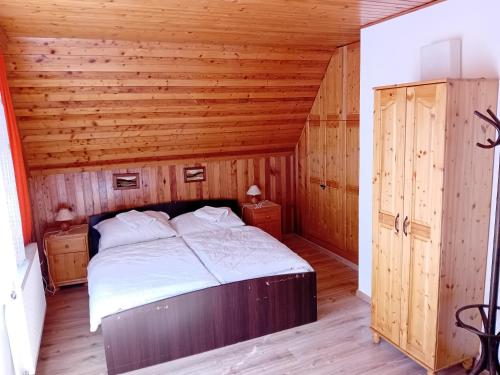 a bedroom with a bed in a wooden room at Chata Studnička in Jakubovany