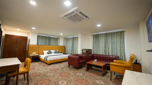 ein Hotelzimmer mit Bett, Sofa und Stühlen in der Unterkunft Mystical Valley View Resort and Spa, Udaipur in Udaipur