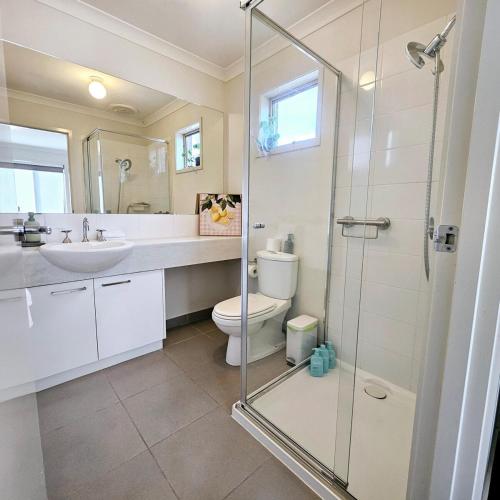 a bathroom with a shower and a toilet and a sink at Comfort on Mozart in Shepparton