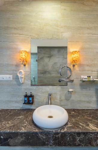 ein Badezimmer mit Waschbecken und Spiegel in der Unterkunft Mystical Valley View Resort and Spa, Udaipur in Udaipur