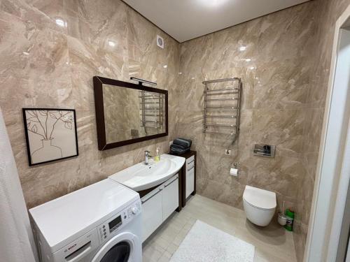 a bathroom with a sink and a washing machine at Parkr Land Elite in Uzhhorod