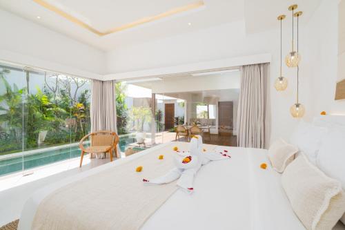 a bedroom with a white bed and a large window at Villa Lior - 1BR Luxury Hideaway near Nyanyi Beach in Canggu