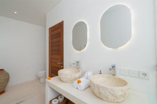 a bathroom with two sinks and two mirrors at Villa Lior - 1BR Luxury Hideaway near Nyanyi Beach in Canggu