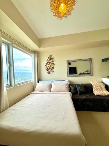 a bedroom with a large bed and a couch at Avida Aspira Studio, 27th Floor, Pool & Gym in Cagayan de Oro