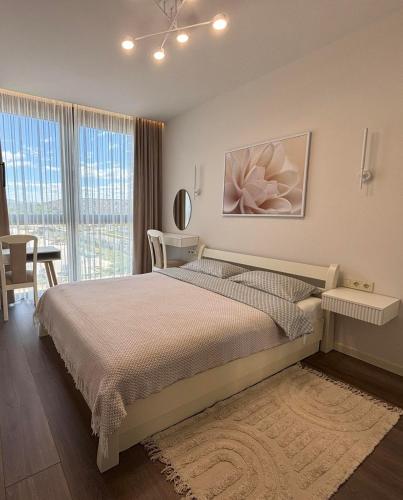 a bedroom with a bed and a large window at Parkr Land Elite in Uzhhorod