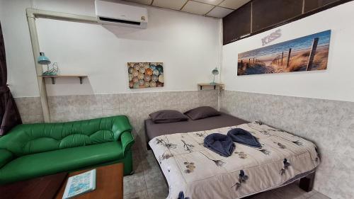 a bedroom with a bed and a green couch at Runa Group House Samed in Ko Samed