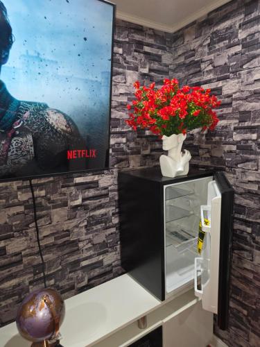 a refrigerator with a vase with red flowers on a counter at Berwyn Alimot Proshortlet-home LLC in Syracuse