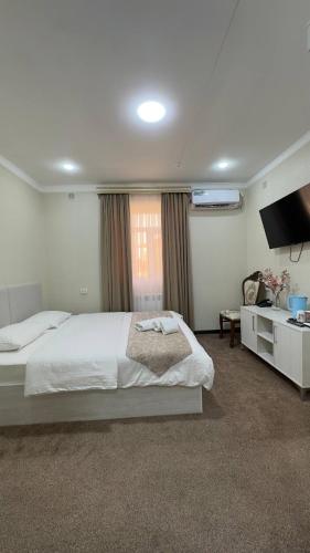 a bedroom with a large bed and a television at Al-Xorazmiy Hotel in Urganch