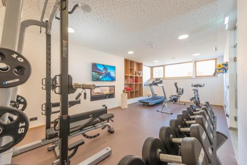 a gym with rows of treadmills and machines at Rittis Alpin Chalets Dachstein in Ramsau am Dachstein