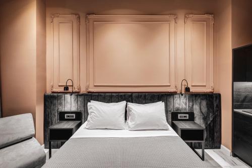 a bedroom with a large bed with two night stands at ATELIER5 Suites in Ermoupoli