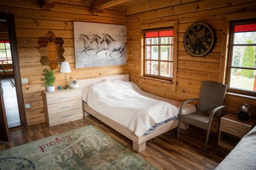 a bedroom with a bed in a log cabin at Lake House Villa pas Eugenija in Migiškiai