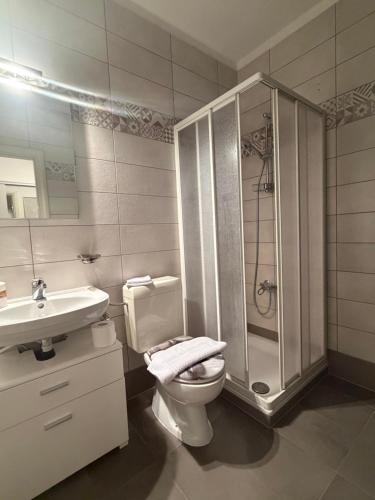 a bathroom with a shower and a toilet and a sink at NiceStay in Lugano