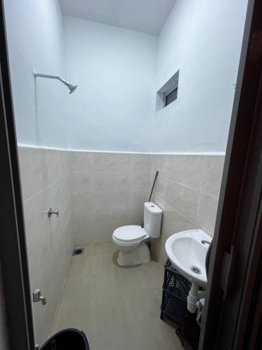 a bathroom with a toilet and a sink at DBreeze Homestay in Pengerang