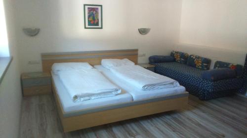 ein kleines Schlafzimmer mit einem Bett und einem Sofa in der Unterkunft Michael Holaus in Aschau