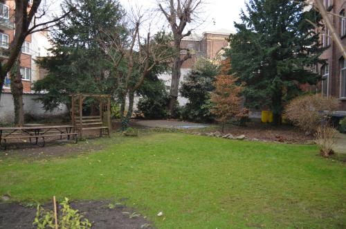 a yard with a park with a picnic table and trees at Institute Of Cultural Affairs in Brussels