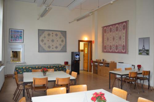 a large room with tables and chairs and a kitchen at Institute Of Cultural Affairs in Brussels