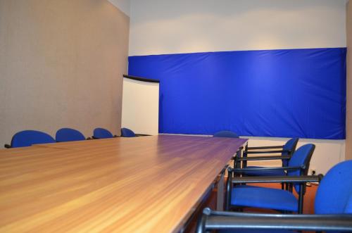 a conference room with a large table and blue chairs at Institute Of Cultural Affairs in Brussels