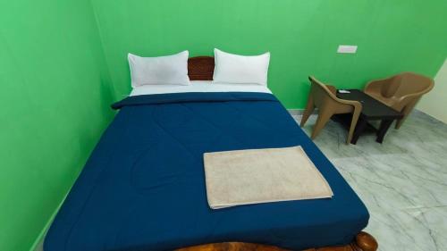 a bedroom with a blue bed with a green wall at Ronazio Beach View Residency in Auroville