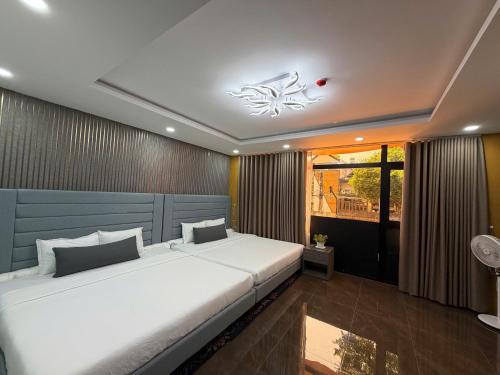 a bedroom with a large white bed in a room at Kim's Hotel in Buon Ma Thuot
