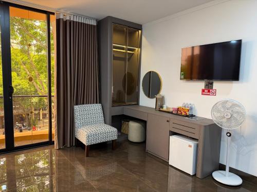a room with a desk and a chair and a television at Kim's Hotel in Buon Ma Thuot