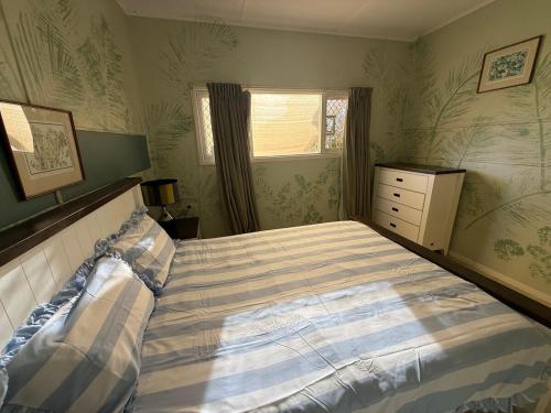 a bedroom with a bed and a dresser and a window at Huge comfy 4br home near CBD in Geraldton