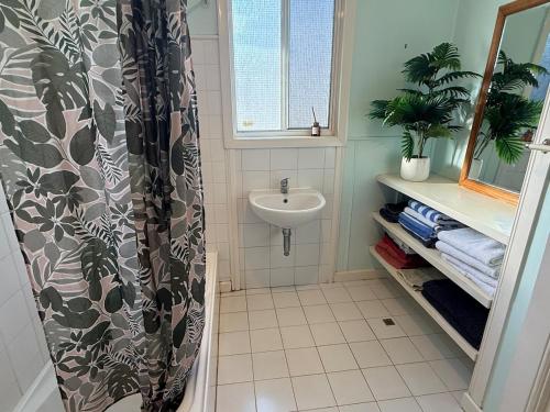 a bathroom with a sink and a shower curtain at Huge comfy 4br home near CBD in Geraldton