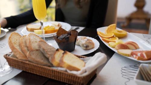 a table topped with plates of bread and orange slices at Hotel President in Zagreb