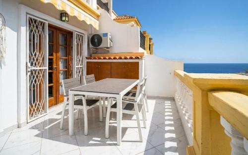 a table and chairs on a balcony with the ocean at Monamie-Windsor Park in Adeje
