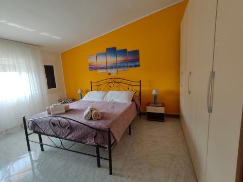 a bedroom with a bed and a yellow wall at Casa vacanze da Roberta a pochi km da Oristano in Simaxis