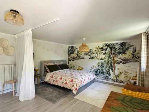 a bedroom with a bed and a painting on the wall at Le Cerisier in Giverny