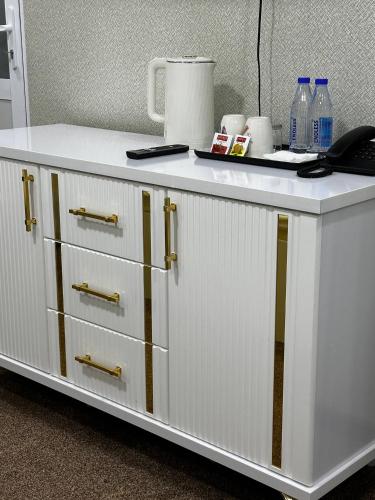 a white cabinet with drawers and bottles on top of it at Al-Xorazmiy Hotel in Urganch