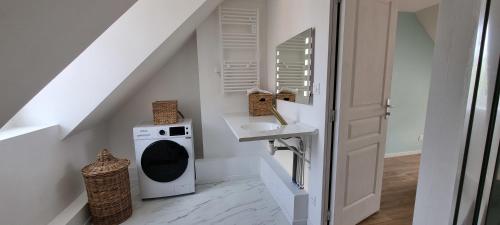 a bathroom with a sink and a washing machine at Le Charmant in Dieppe