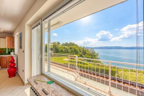 ein großes Küchenfenster mit Blick auf das Wasser in der Unterkunft Debeli Rtič Apartments in Ankaran