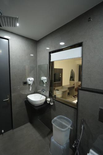 a bathroom with a toilet and a sink and a mirror at Hotel Ace Inn in Dr. Babasaheb Ambedkar International
