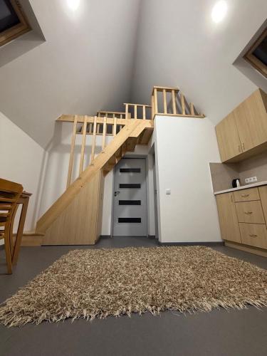 a loft room with a wooden staircase and a rug at Apartament in Chişinău