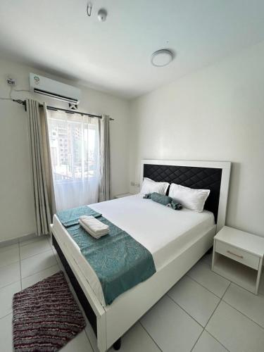 a bedroom with a large bed and a window at BMW Buxton point Apartment in Mombasa