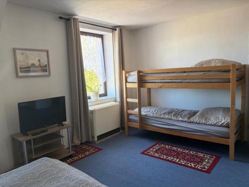 a bedroom with two bunk beds and a television at Ferienwohnung Ankerplatz in Rankwitz