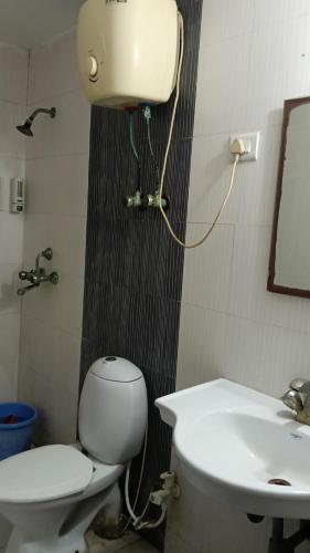 a bathroom with a toilet and a sink at Shubharohi stay in Chhatikara