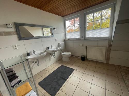 a bathroom with two sinks and a toilet at Gästehaus Wedework in Wedemark