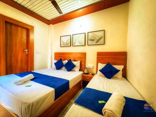 a bedroom with two beds with blue pillows at Hotel Vrinda mohan kunj Near Prem Mandir in Vrindāvan