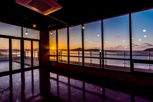 a view of the ocean from a room with windows at Hu An Stay Hotel in Seogwipo