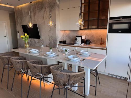 a kitchen with a large white table and chairs at Aqua Concept Apartment Sol Marina in Wiślinka