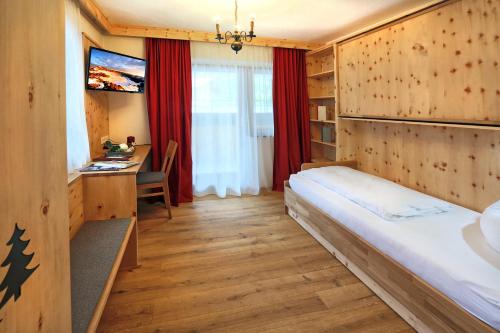 a hotel room with a bed and a desk at Aktivhotel Waldhof in Oetz
