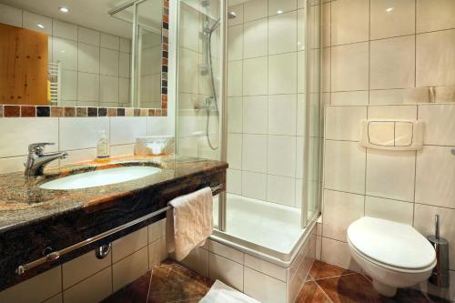 a bathroom with a sink and a shower and a toilet at Aktivhotel Waldhof in Oetz