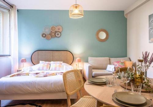 a bedroom with a bed and a table and a couch at L'escale - proche Homme de Fer in Strasbourg