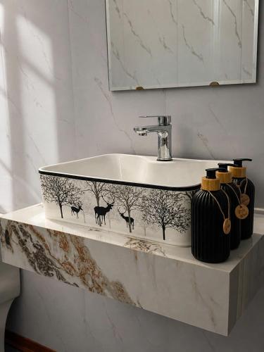 a bathroom with a sink with deer and trees on it at La Pausa Homestay in Kỳ Vĩ