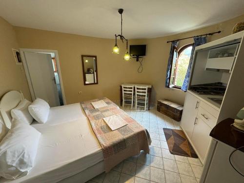 a bedroom with a large white bed and a kitchen at Christina's Apartments in Vathi