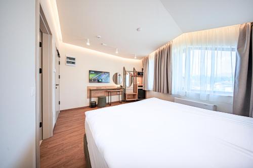 a hotel room with a large bed and a window at Aparthotel SamElyon in Samokov