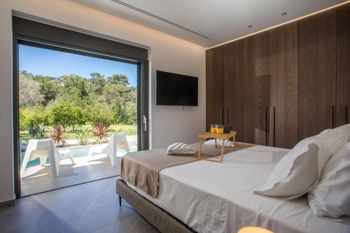 a bedroom with a bed and a sliding glass door at Casadi Luxury Villa in Ialysos